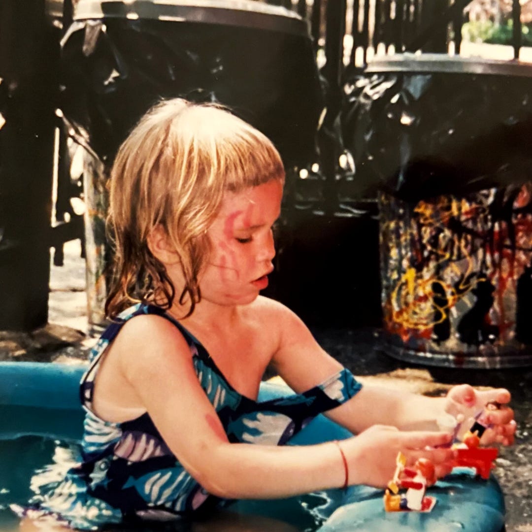 Girl playing in kiddie pool outdoors in city yard Girl playing in kiddie pool outdoors in city yard