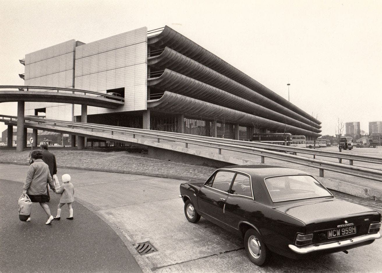 A black and white photograph fo Preston Bus Station and car park in the background and a 1970s car in the foreground