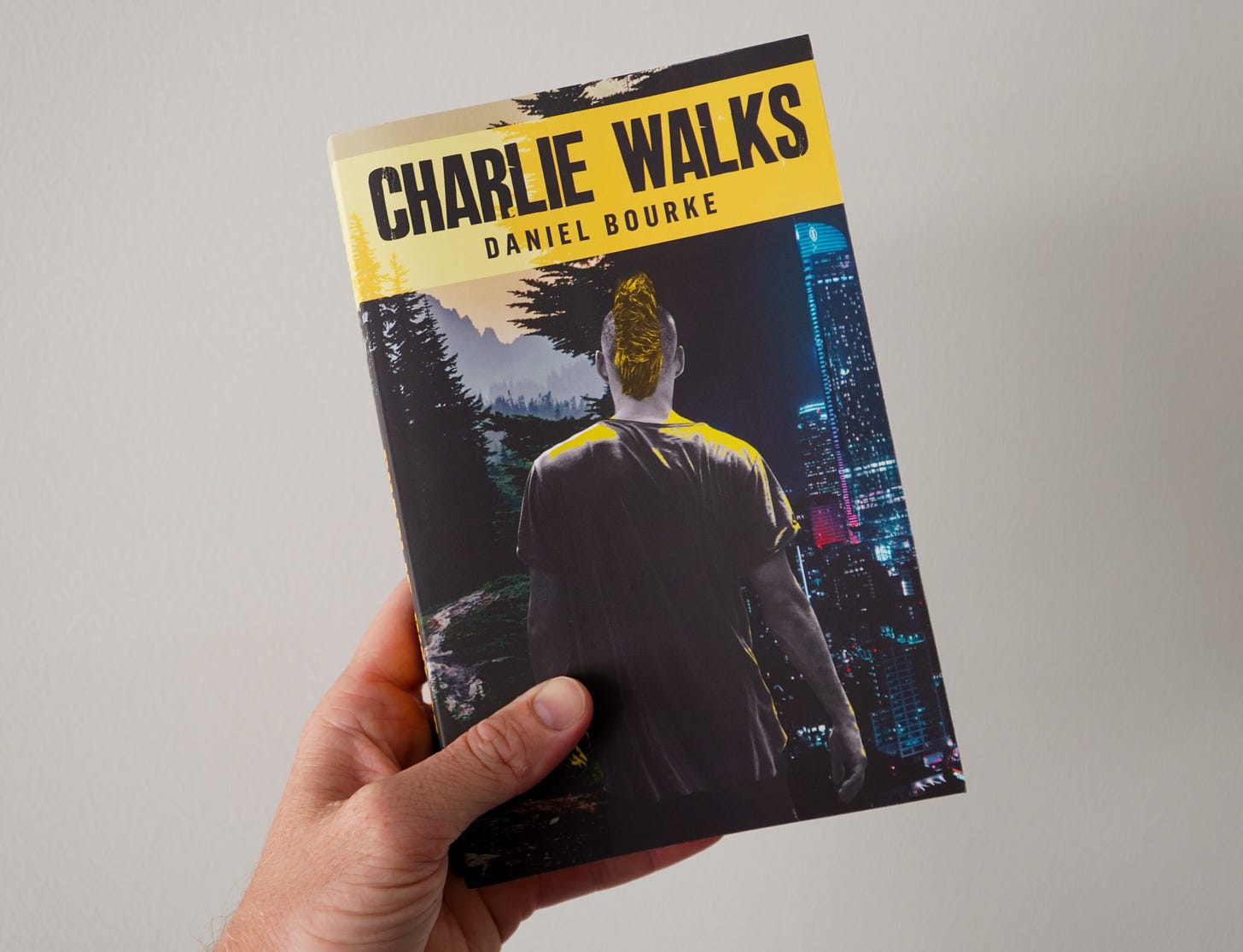 Person holding Charlie Walks paperback copy