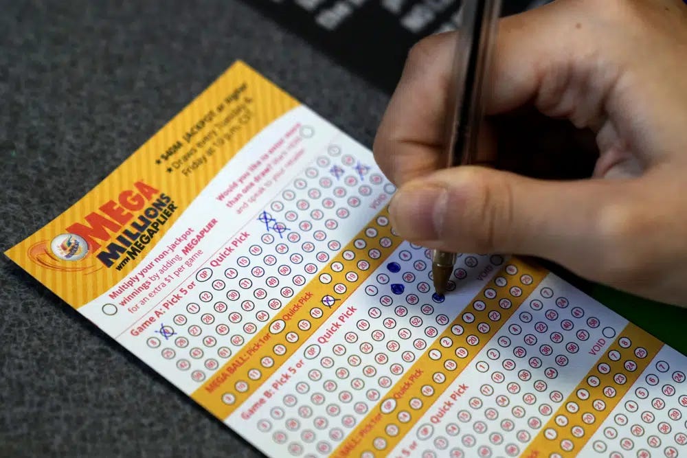 A customer fills out a Mega Millions lottery ticket at a convenience store Tuesday, Jan. 3, 2023, in Northbrook, Ill. (AP Photo/Nam Y. Huh)