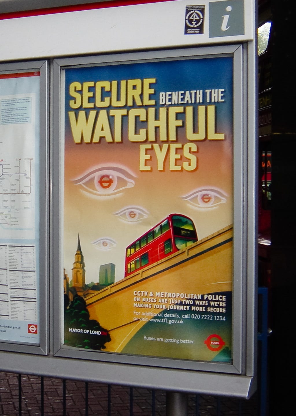 A poster in the London public transit system. The poster reassures bus riders that they are “secure beneath the watchful eyes.”