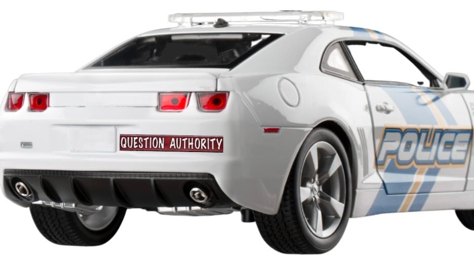 Police car with bumper sticker reading, “question authority.”