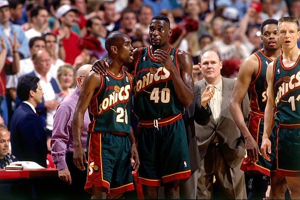 Shawn Kemp and Gary Payton of the Seattle SuperSonics discuss strategy during Game Six of the 1996 NBA Finals against the Chicago Bulls at the United...