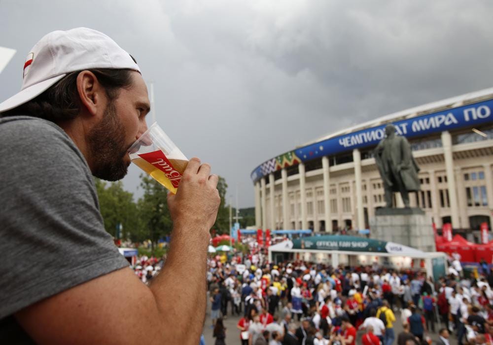FILE - In this July 11, 2018 photo, a man drinks a beer in a Budweiser pavilion in front of the Lenin statue and the Luzhniki Stadium as fans arrive for the semifinal match between Croatia and England, during the 2018 soccer World Cup in Moscow, Russia. The sale of all beer with alcohol at the eight World Cup stadiums in Qatar has been banned. The decision comes only two days before the soccer tournament is set to start. Non-alcoholic beer will still be available for fans at the 64 matches. FIFA says the decision was made "following discussions between host country authorities and FIFA." (AP Photo/Rebecca Blackwell, File)