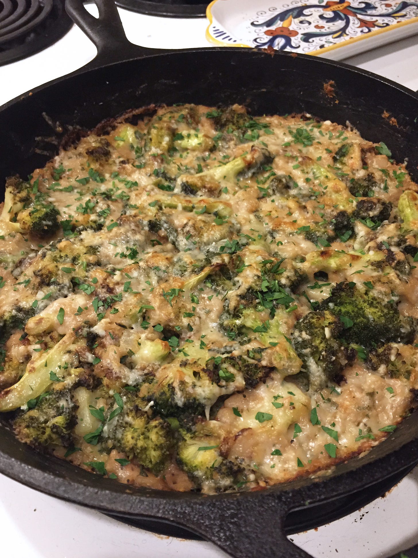a cast iron pan filled with a cheesy broccoli casserole