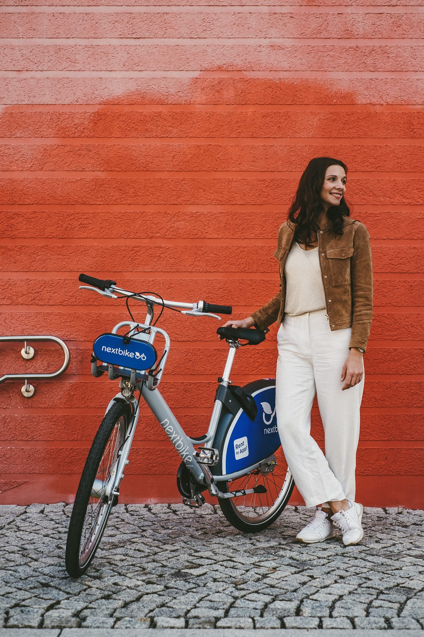 Woman standing next to a bike from a bike-sharing company