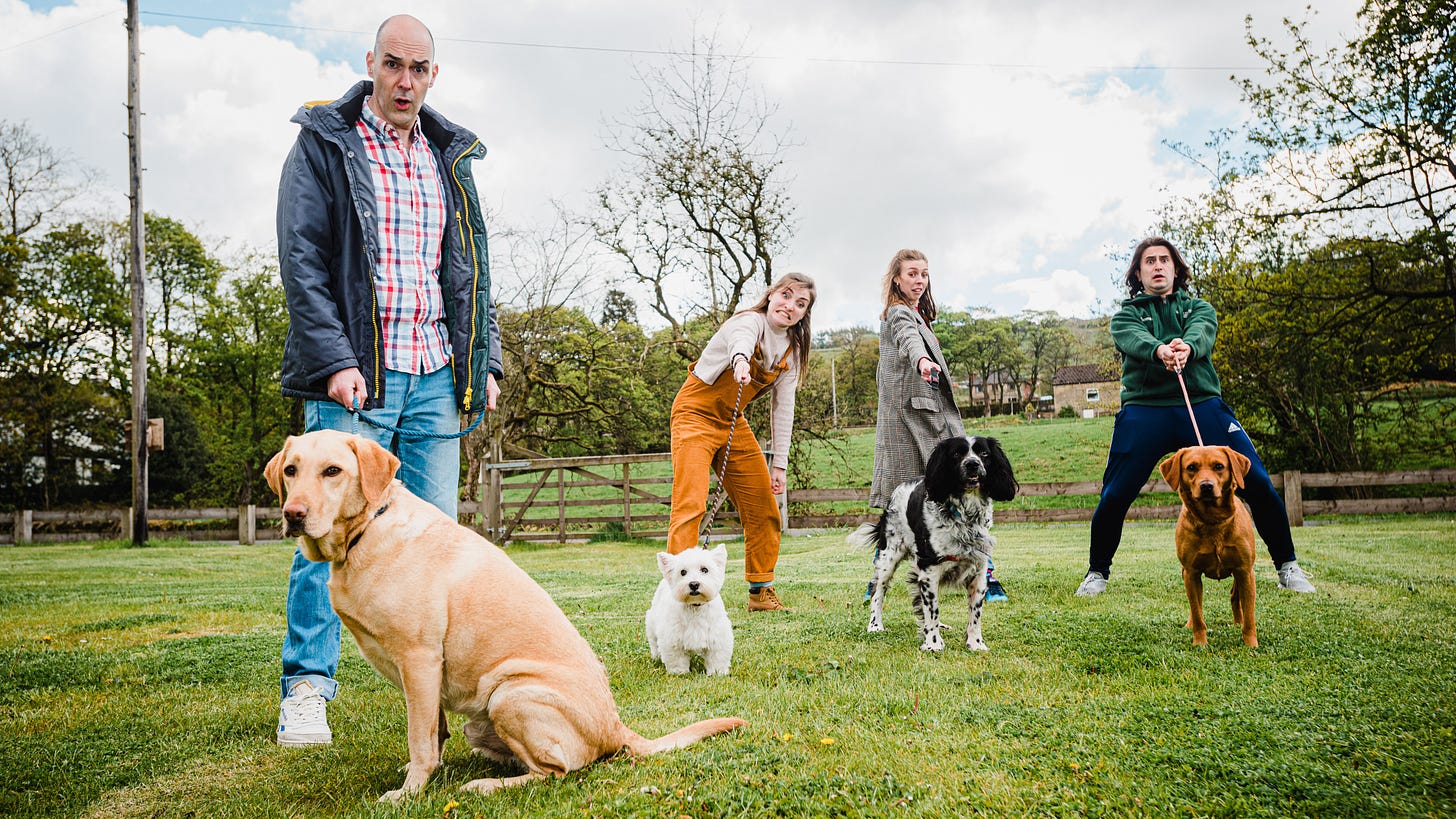 James Mclean, Rachel Benson, Elizabeth Robin and Thomas Cotran with dogs in a field.