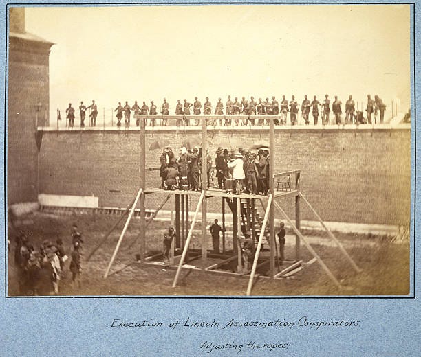 Full-length view of President Abraham Lincoln's assassins, wearing hoods over their heads, standing on the gallows prior to their execution as the...