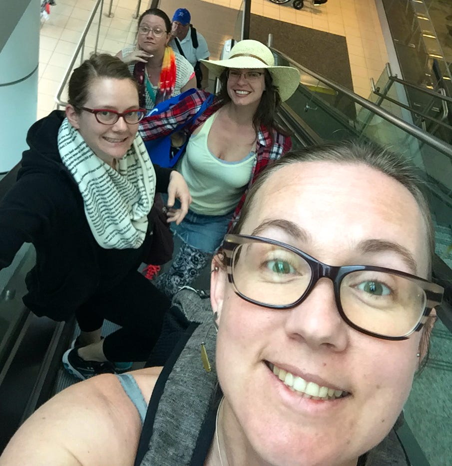 four white women on an escalator