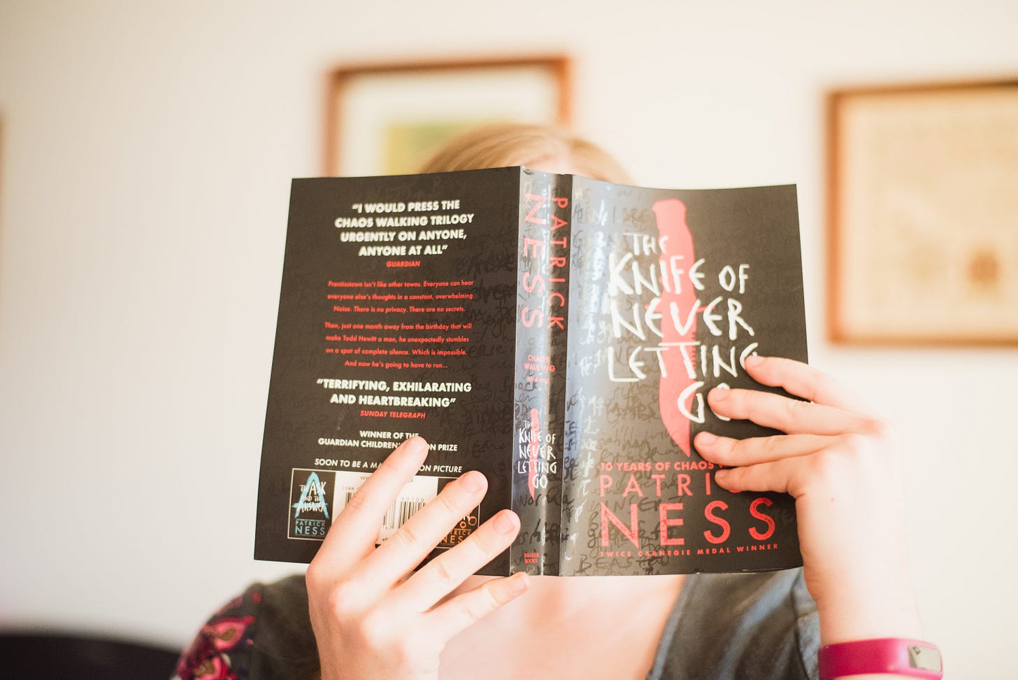 Person holding the Knife of Never Letting Go book