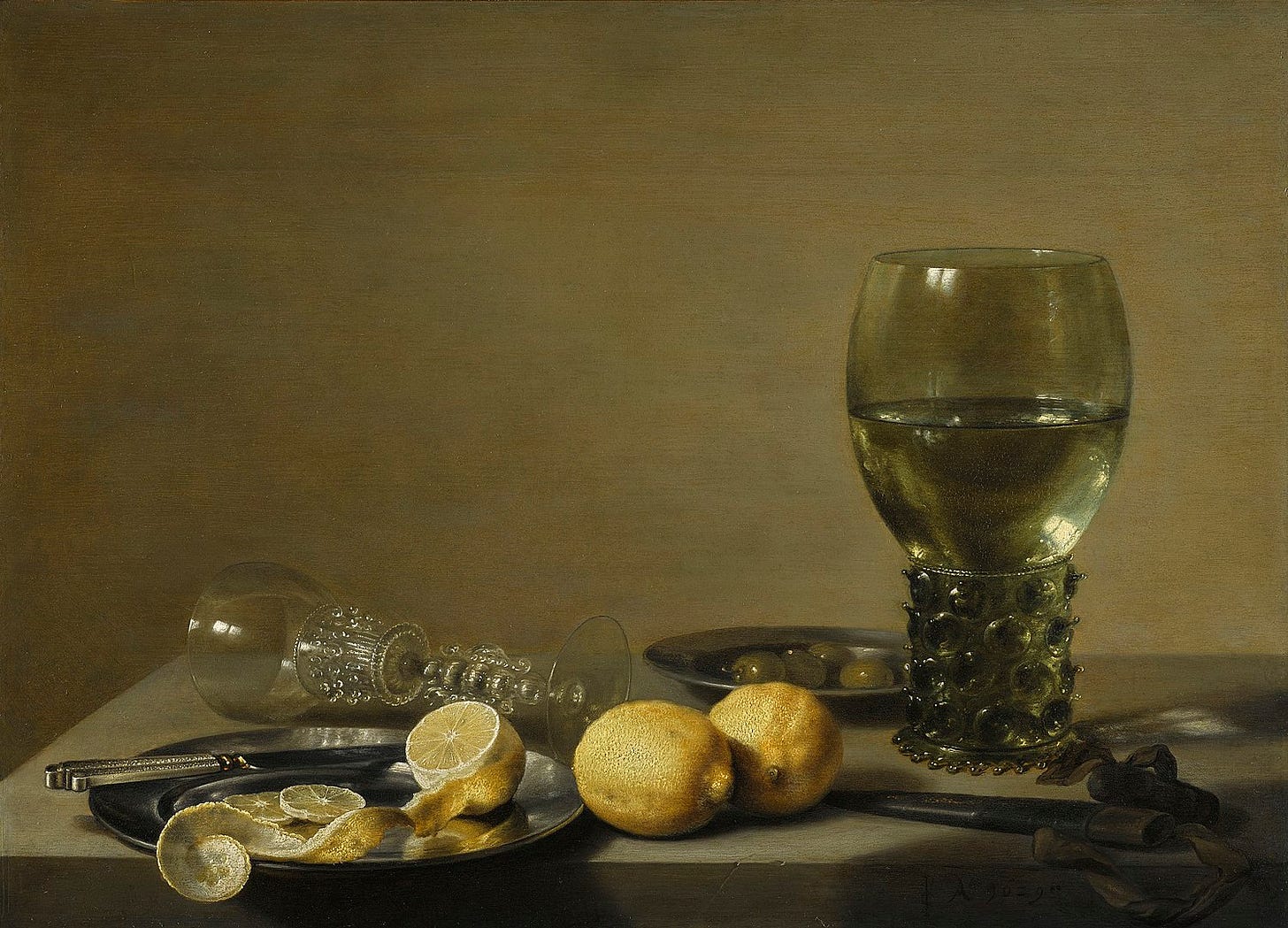 An oil painting of a tabletop with a silver platter holding a knife and an artfully peeled lemon, two whole lemons, a fancy goblet tipped on its side, a fancy goblet upright and full of water, and a small dish of olives. An oil painting of a tabletop with a silver platter holding a knife and an artfully peeled lemon, two whole lemons, a fancy goblet tipped on its side, a fancy goblet upright and full of water, and a small dish of olives.