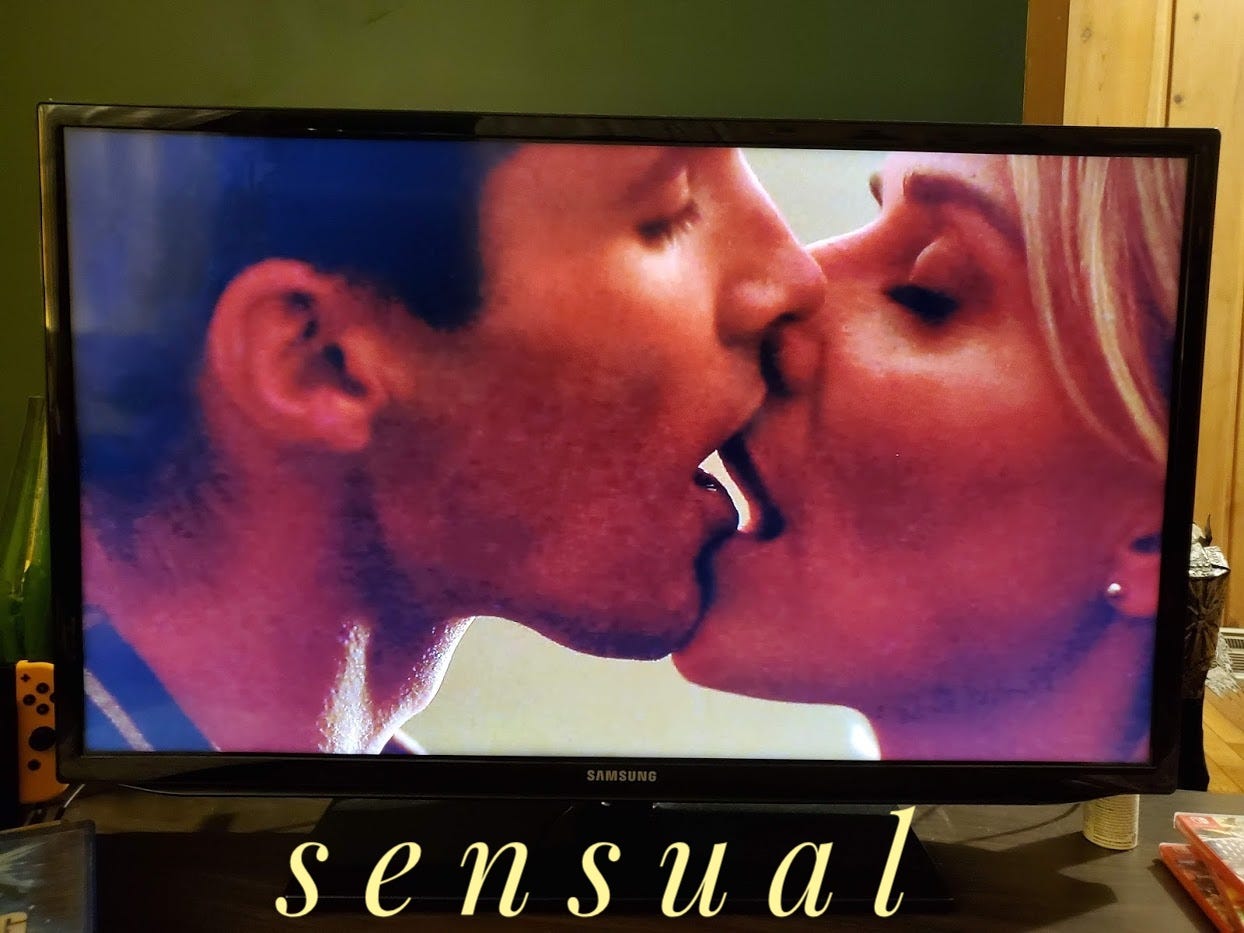Jake and Tanya kissing, it looks terrible, it is captioned "sensual" in a sexy script font