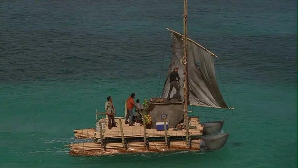Ariel shot of the raft sailing on a calm blue sea.