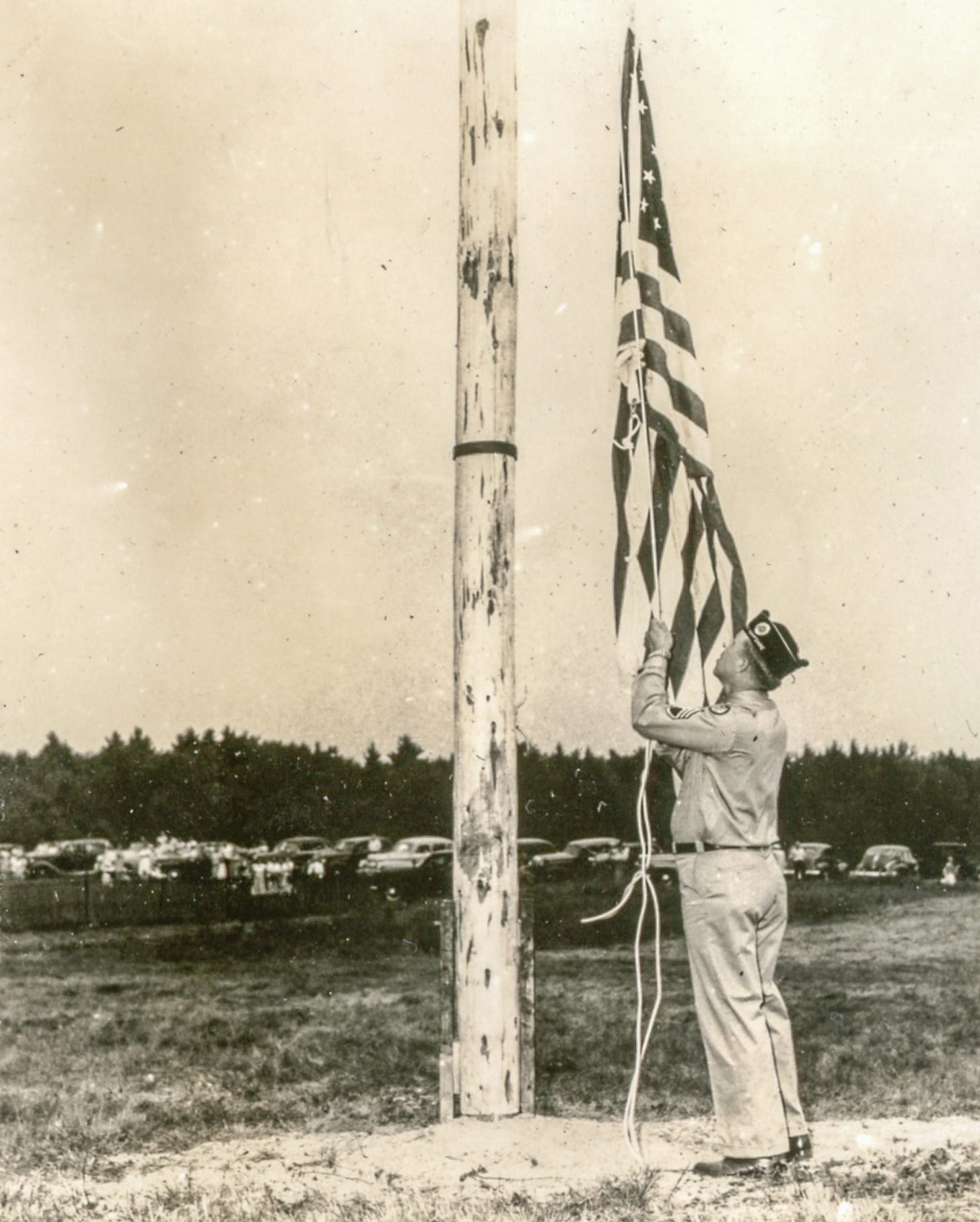 Man in uniform raising flag