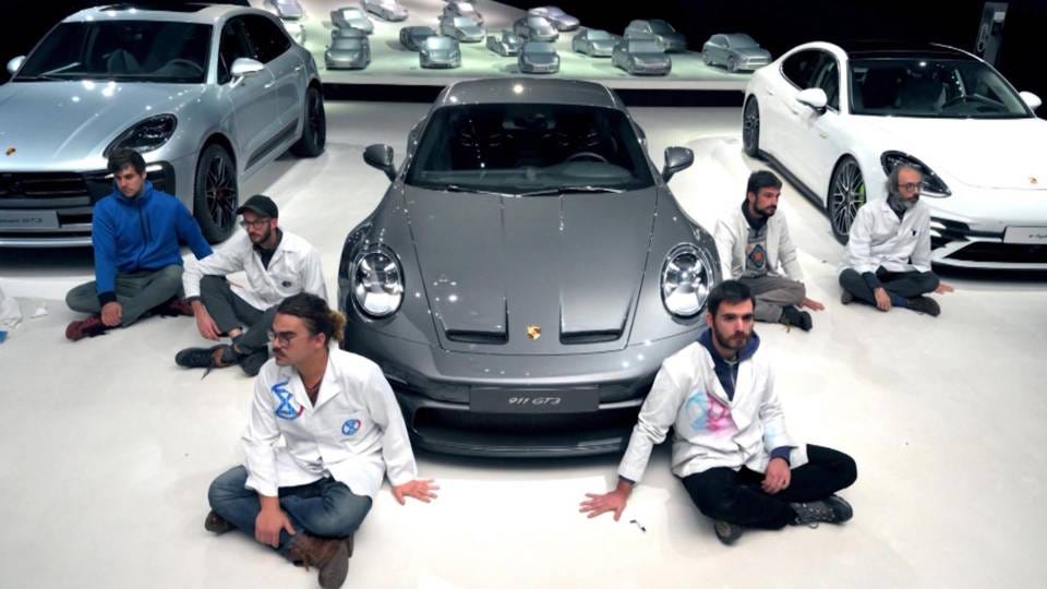 6 Scientist Rebellion activists glued to a Volkswagen exhibit