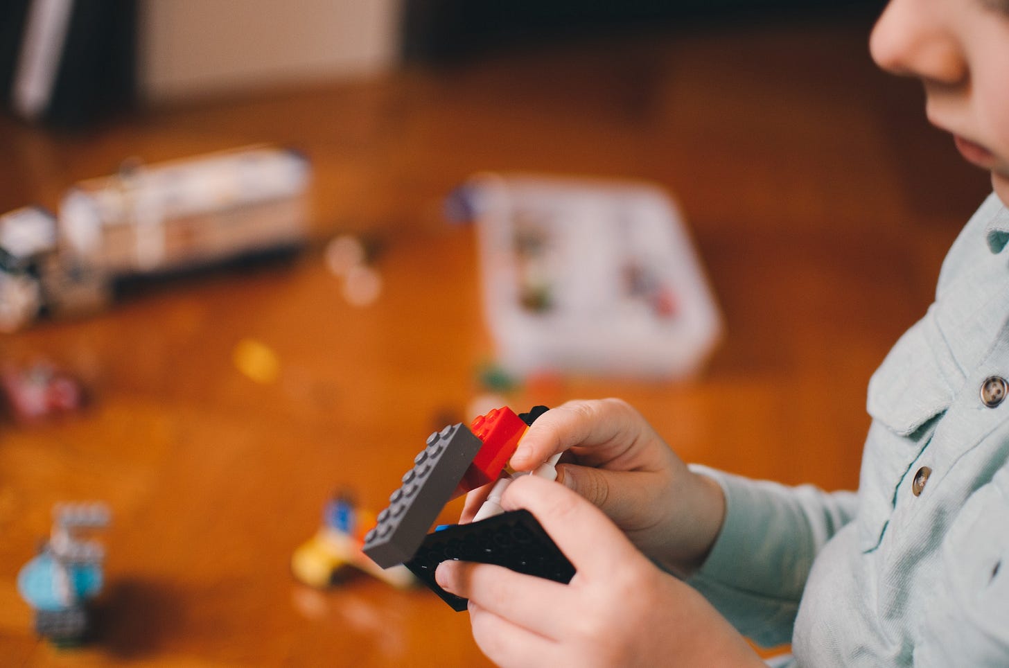 Child playing with lego for article by Larry G. Maguire