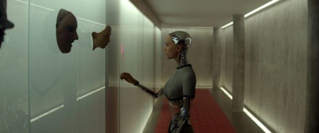 Shot of Alicia Vikander, as Ava, in Ex Machina, looking at masks hanging in the hallway