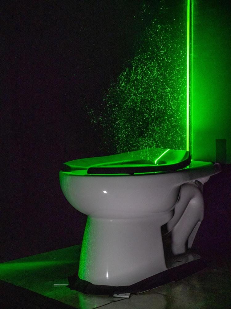 A powerful green laser helps visualize the aerosol plumes from a toilet 