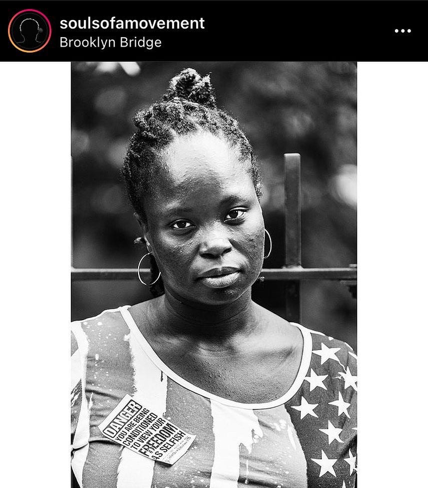 Black woman protesting on Brooklyn Bridge. Photo by Souls of a Movement (Instagram).