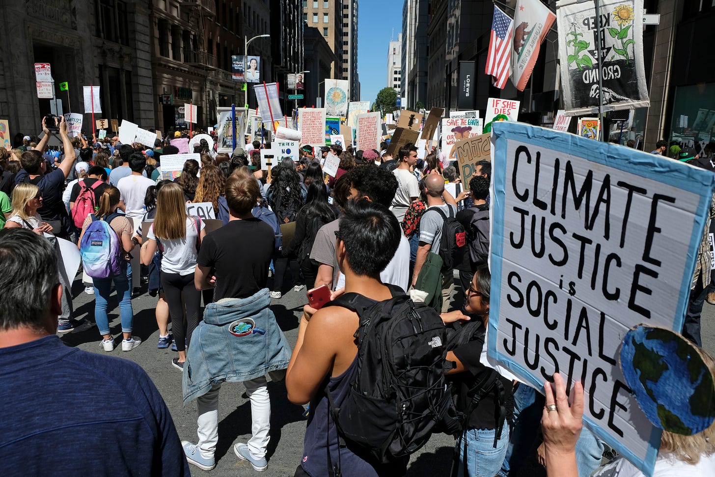 Protestor in crowd holds sign that says 'Climate justice is social justice'