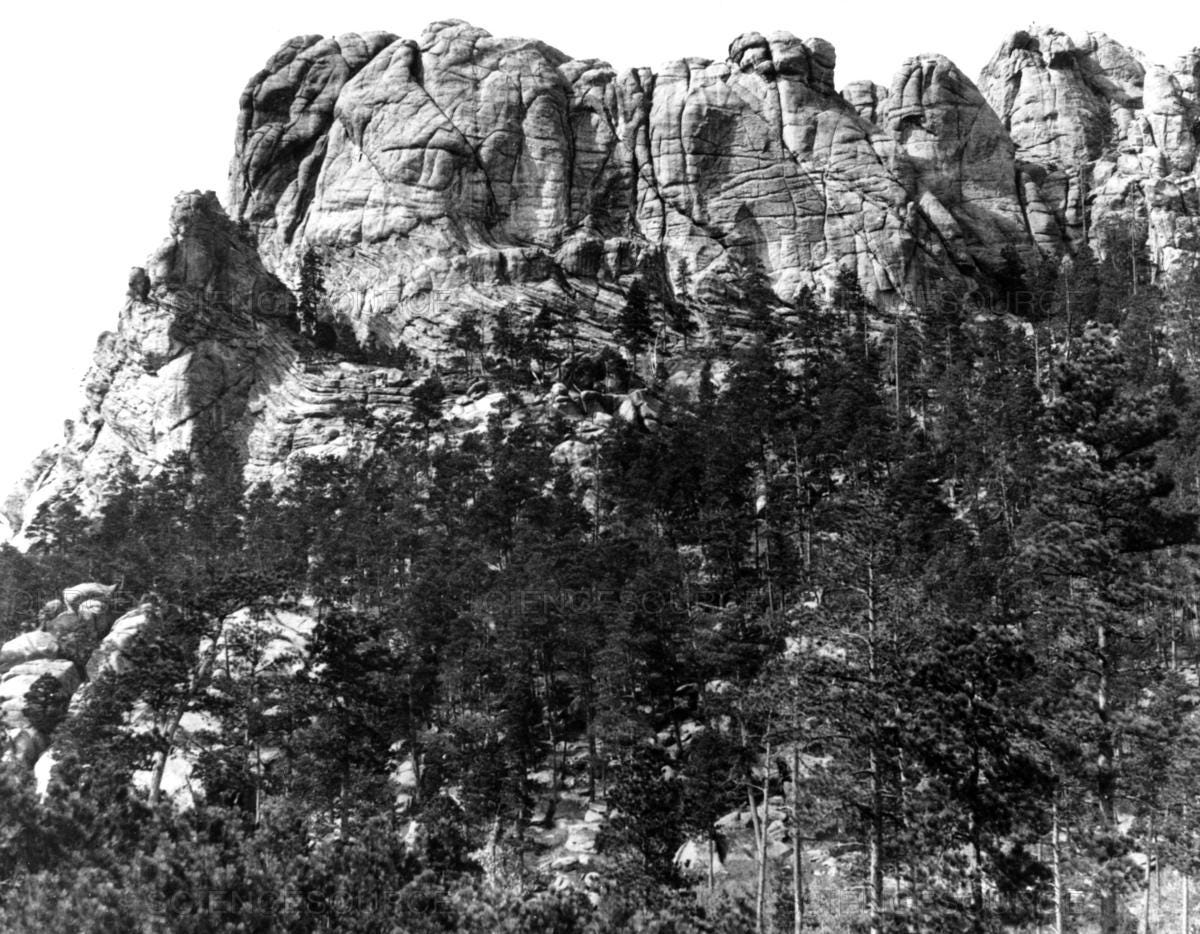 Black and white photo of the Six Grandfathers cliff face before it was defaced by the carving of Mount Rushmore.