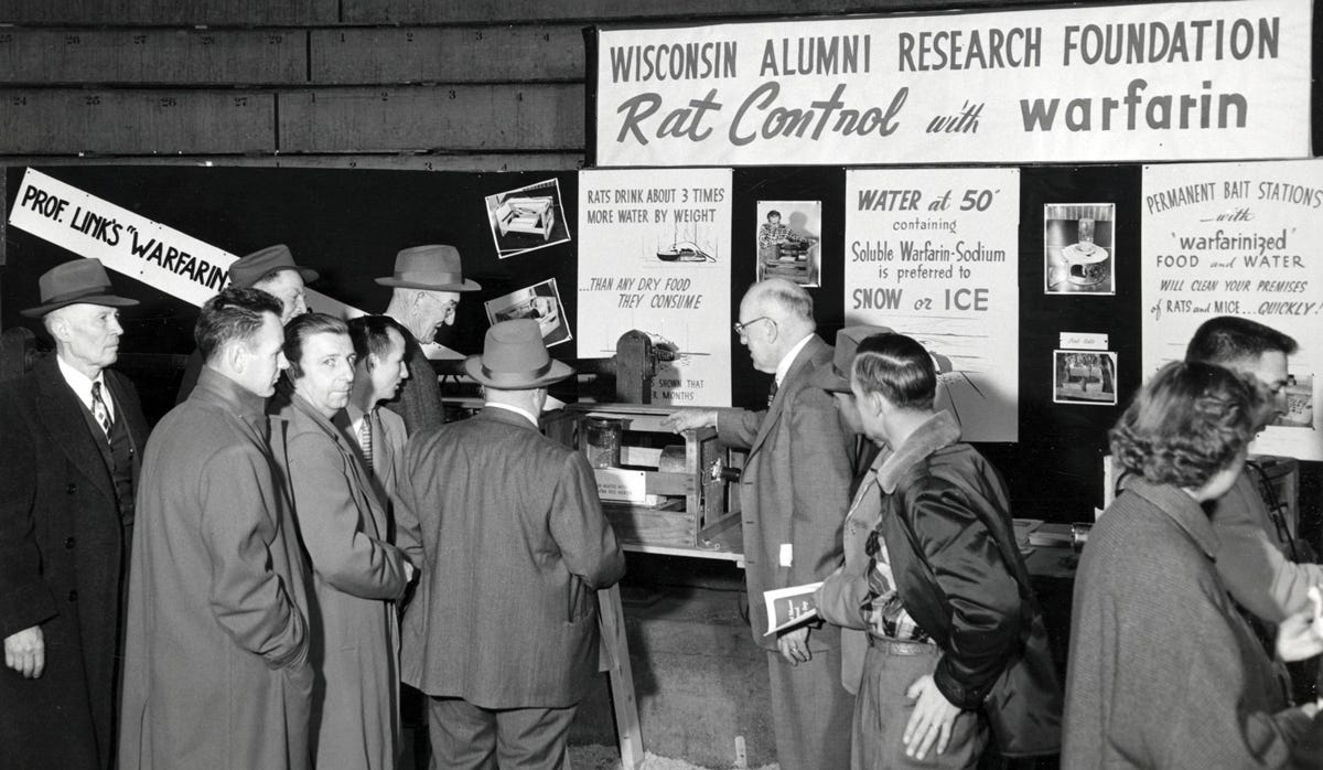  Attendees at the 1954 Farm and Home exhibit examine Link’s display showing the effect of warfarin on rats. Photograph by William Wollin. UW–Madison Archives/ID S16314. 