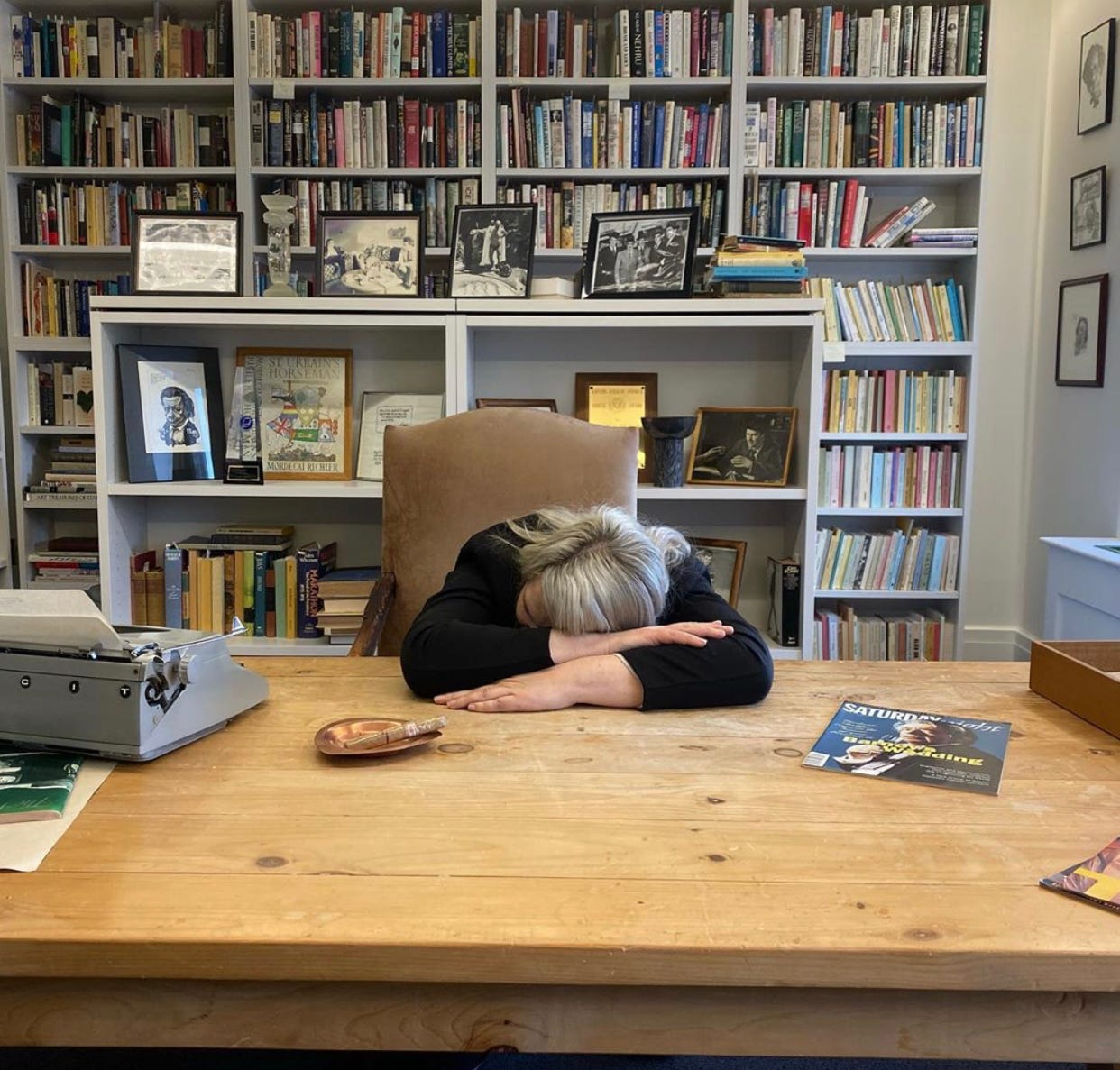 Kathryn Mockler laying her head on a wood desk.