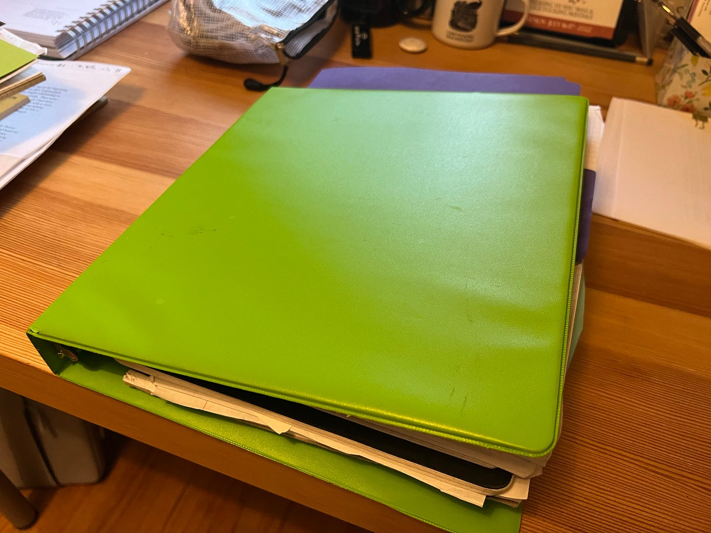 Green binder on a desk