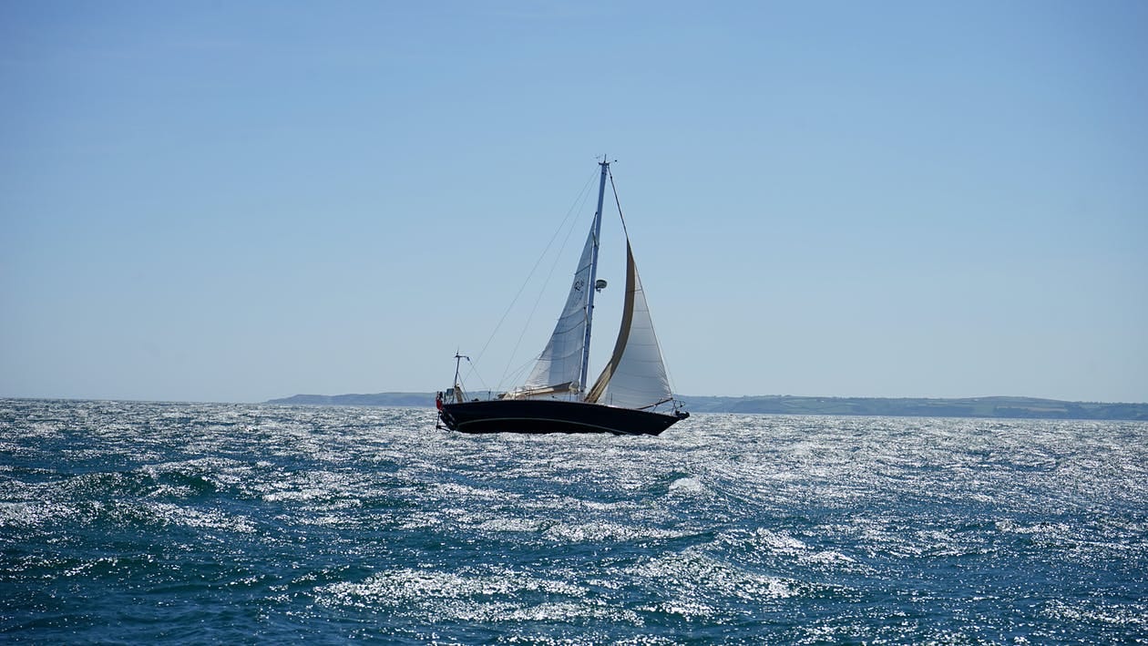 Free White and Black Sail Boat on Ocean Stock Photo