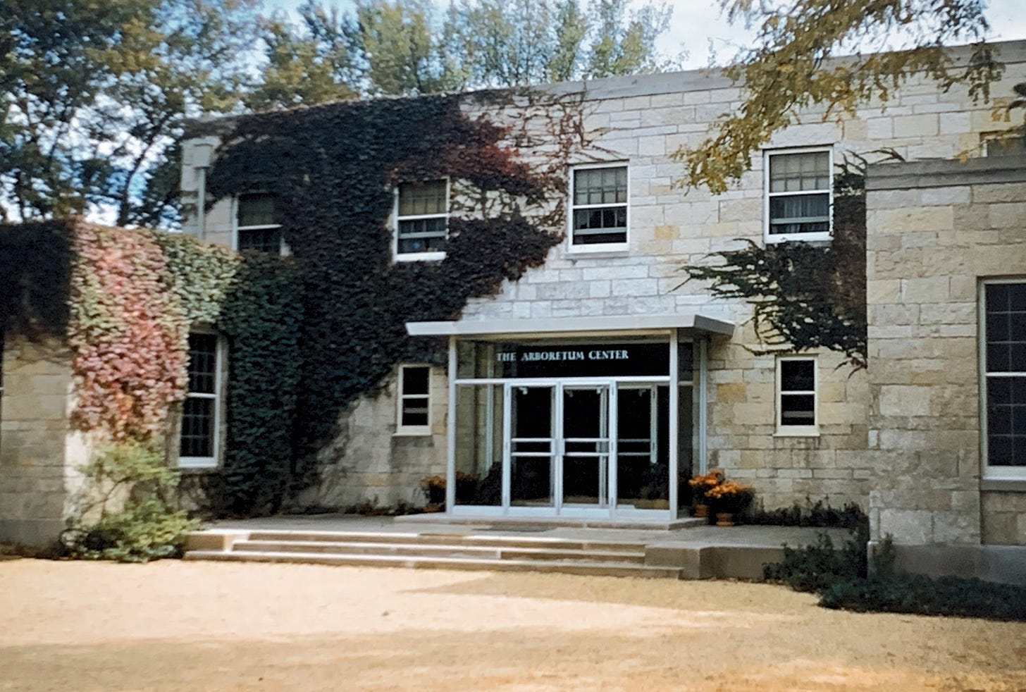 Exterior of the Arboretum Center, a stone building covered partially with ivy.