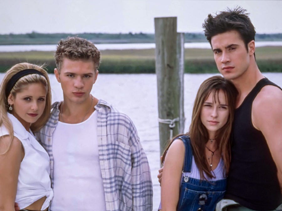 The four protagonists of I Know What You Did Last Summer  offer very serious looks at the camera, standing on a dock in front of the waterfront.