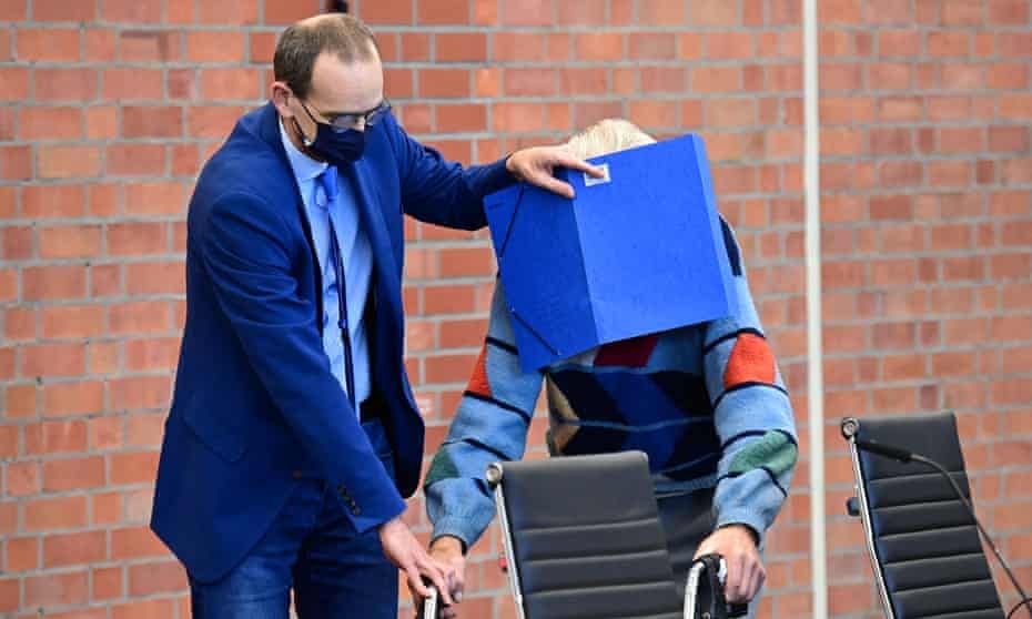 The defendant, right, arriving at court in October last year with walker and someone shielding his face