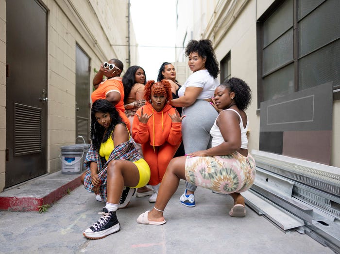 L-R Sydney Bell, Charity Holloway, Arianna Davis, Ashley Williams, Jayla Sullivan, Asia Banks, and Kiara Mooring, posing in a group photo in an alley way