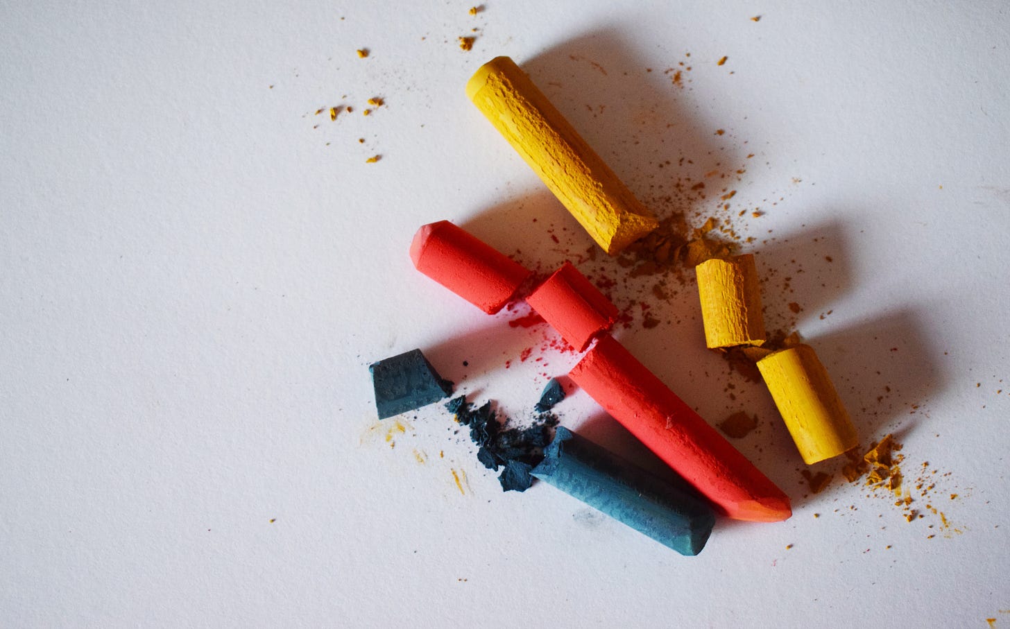 Broken crayons lying on a white background.