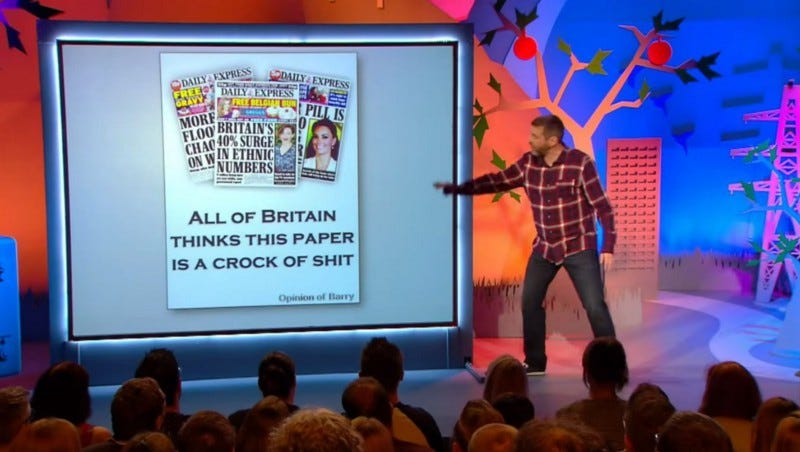 Dave Gorman pointing to a screen with copies of the Daily Express, and an entirely unrelated caption saying ‘All of Britain thinks this paper is a crock of shit’. Not sure which paper it’s referring to.