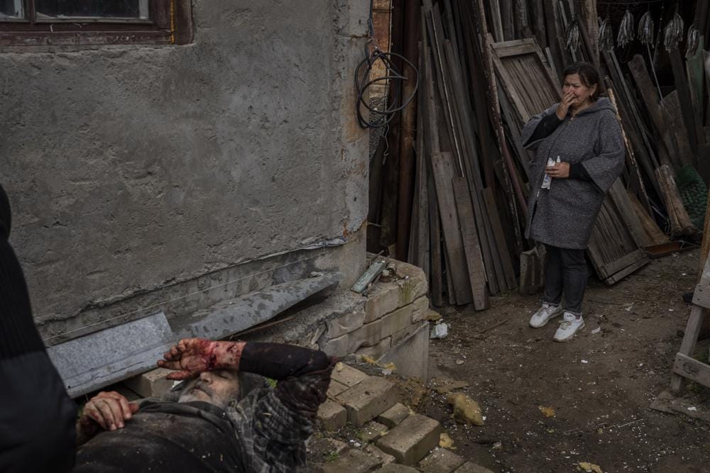 Viktor Anastasiev's wife cries near her wounded husband after a Russian strike in Kherson, southern Ukraine, Thursday, Nov. 24, 2022. (AP Photo/Bernat Armangue)