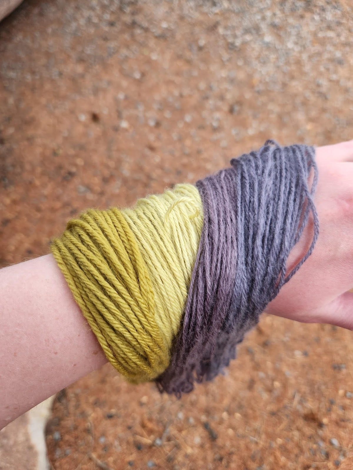Different colored yarn draped over a person's arm