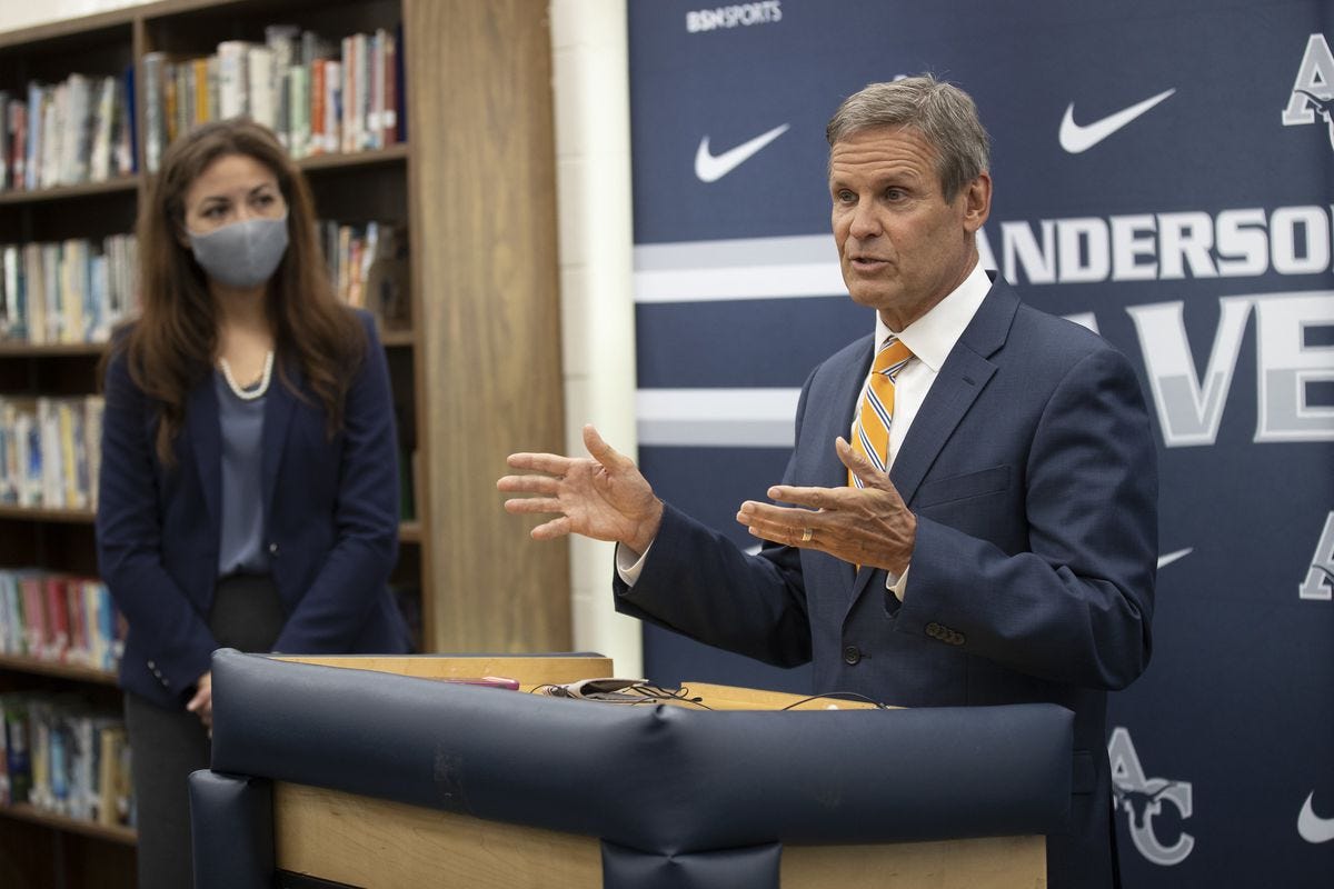 Gov. Bill Lee speaks at a podium while Tennessee Education Commissioner Penny Schwinn looks on