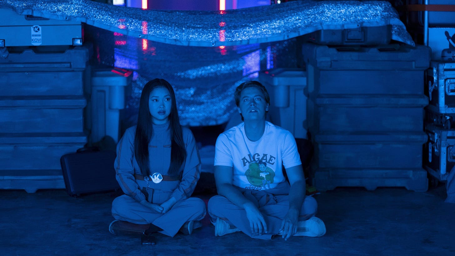 A very blue image of Sophie and Walt sitting cross-legged next to each other.