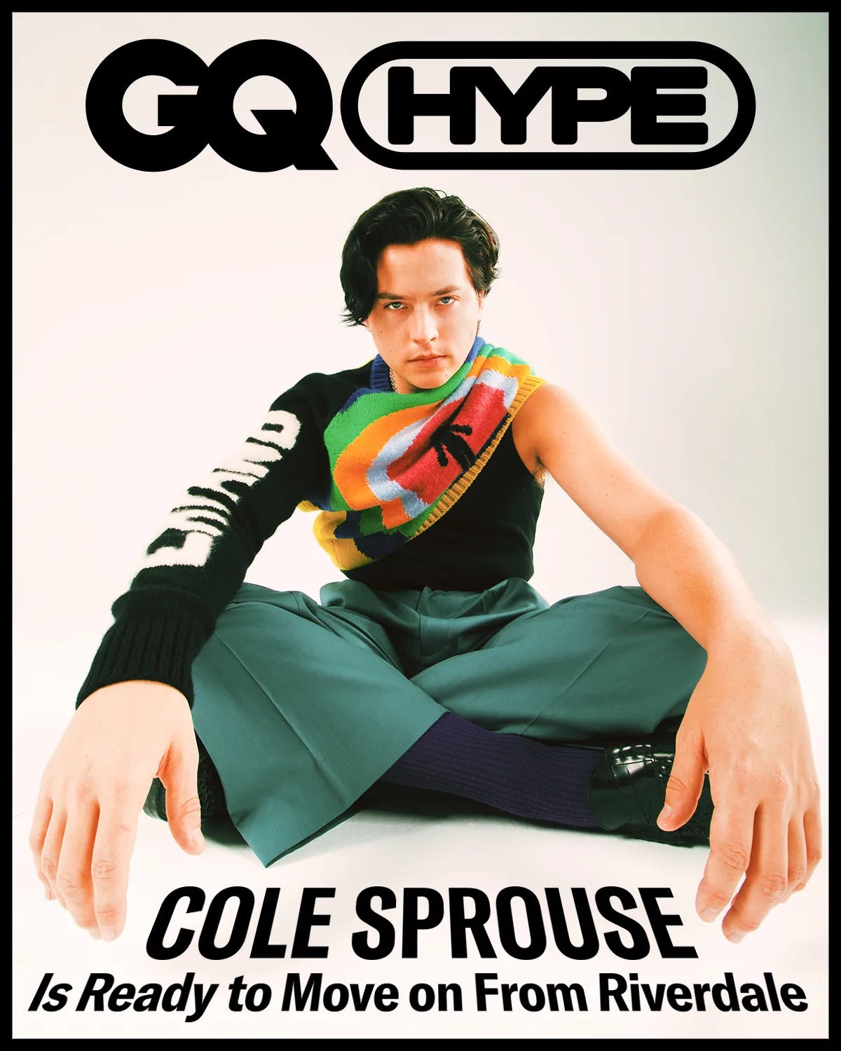 Cole Sprouse is Ready to Move on from Riverdale. He wears a black and orange sweater by The Elder Statesman and green COS pants. 