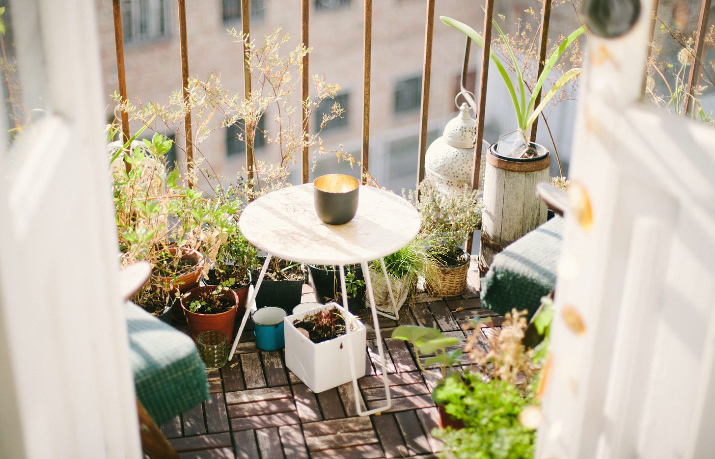Smallbalcony full of plants with one table and a candle