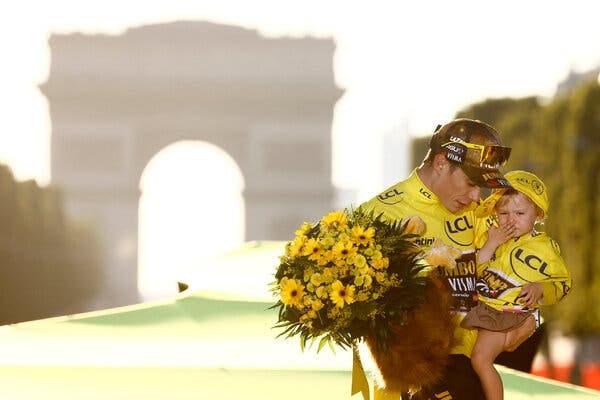 Jonas Vingegaard with his daughter, Frida, on the Champs-Élysées after his victory. He is the second Danish rider to win the Tour.
