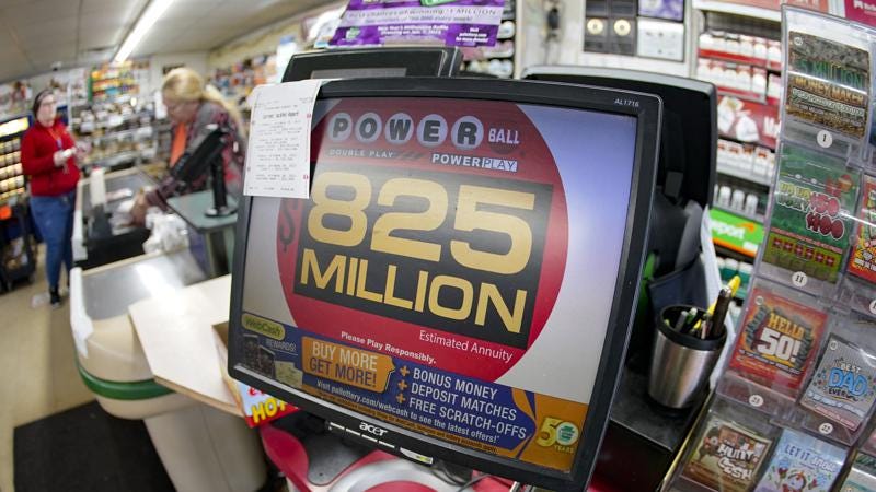 Customers pay for their groceries next to the lottery ticket display showing the jackpot amount for the Saturday, Oct. 29, drawing of the Powerball lottery at a market in Prospect, Pa., Friday, Oct. 28, 2022. Saturday's jackpot projected winnings of an estimated $825 million is the fifth-highest in U.S. history. (AP Photo/Keith Srakocic)