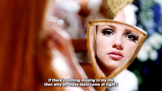 GIF from the music video for Lucky. Britney Spears is seen looking at the camera through a hand mirror. Her eyes are sad, matching the lyrics of the song.