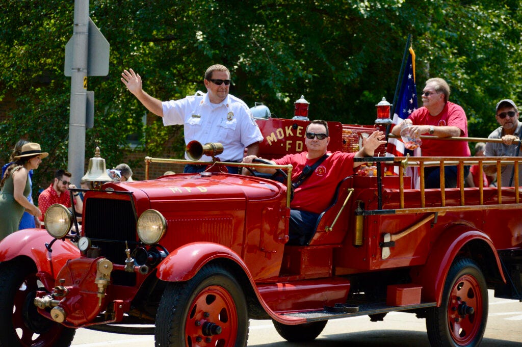 Mokena Fire Protection District Chief Howard Stephens (left) and members of the fire district wave at paradegoers.