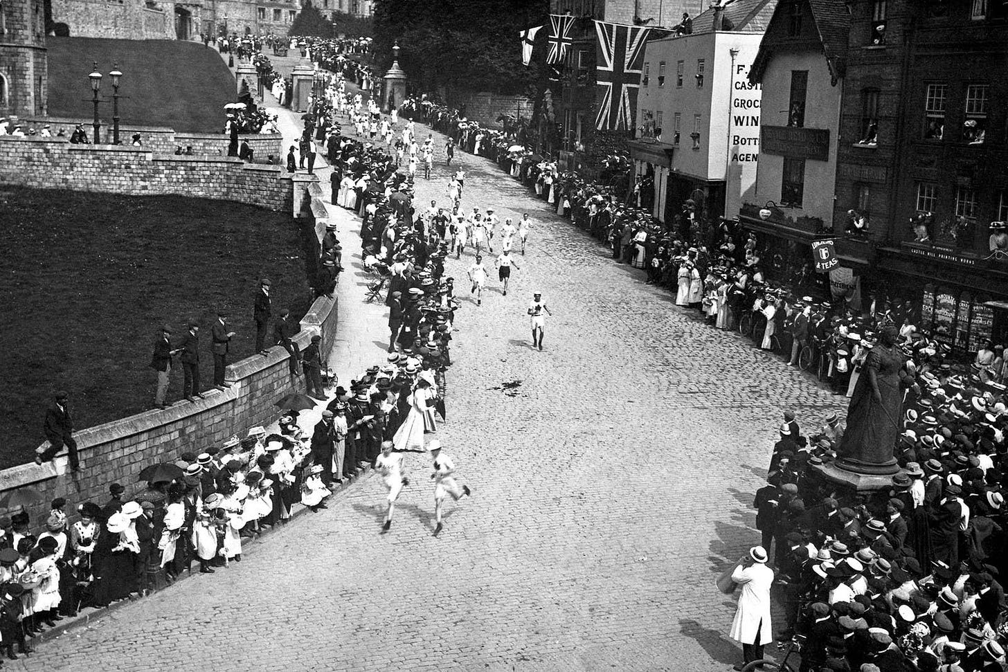 Black and white photo of marathon runners on the road outside Windsor Castle.