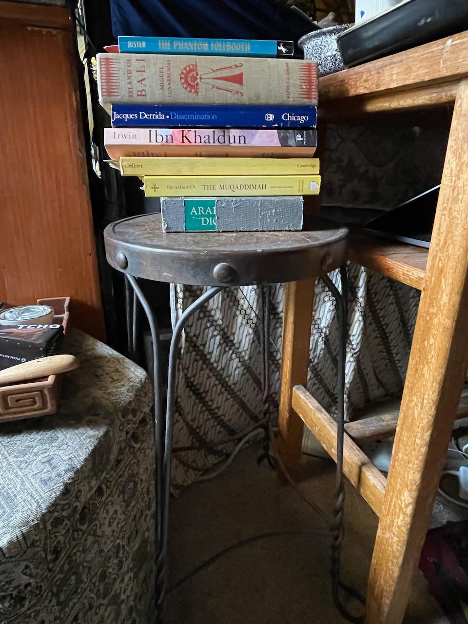 Photo of a pile of books on a stool at the head of Stephen's bed