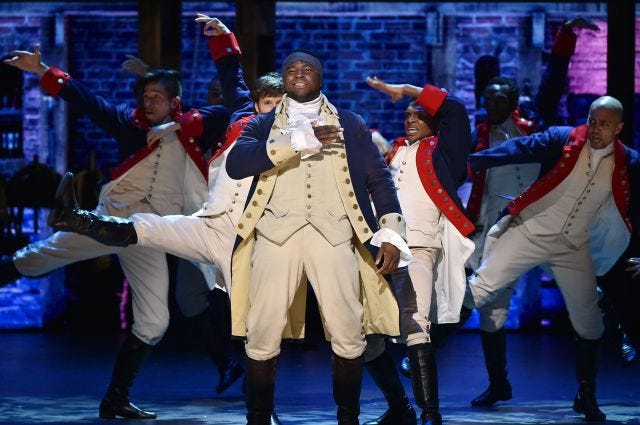 Shot of Daveed Diggs in Hamilton as Thomas Jefferson in "What did I miss?", surrounded by company