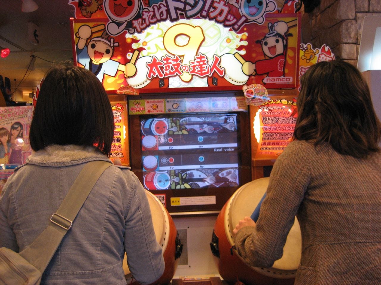 Un par de chicas jugando a Taiko no Tatsujin.