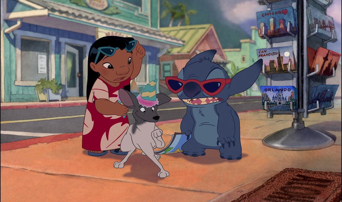 Stitch shoving shaved ice on top of a dog while Lilo watches in conusion.
